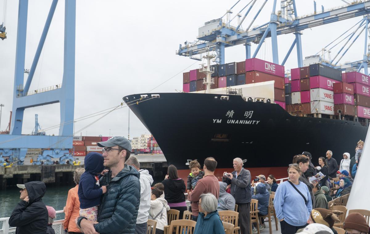 Guests cruise past the ship YM Unaninimity 